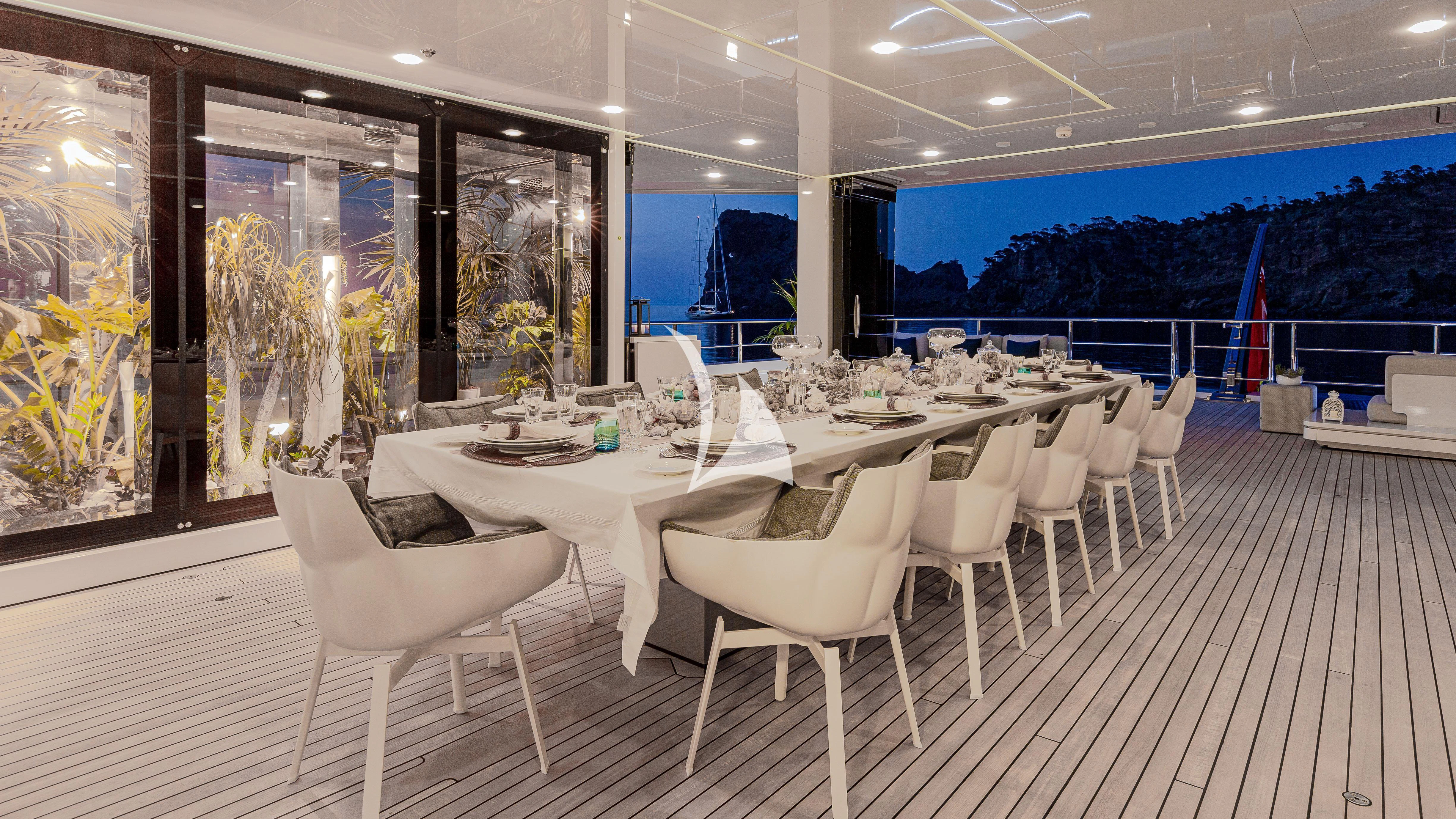 a room with tables and chairs aboard STELLA MARIS Yacht for Sale
