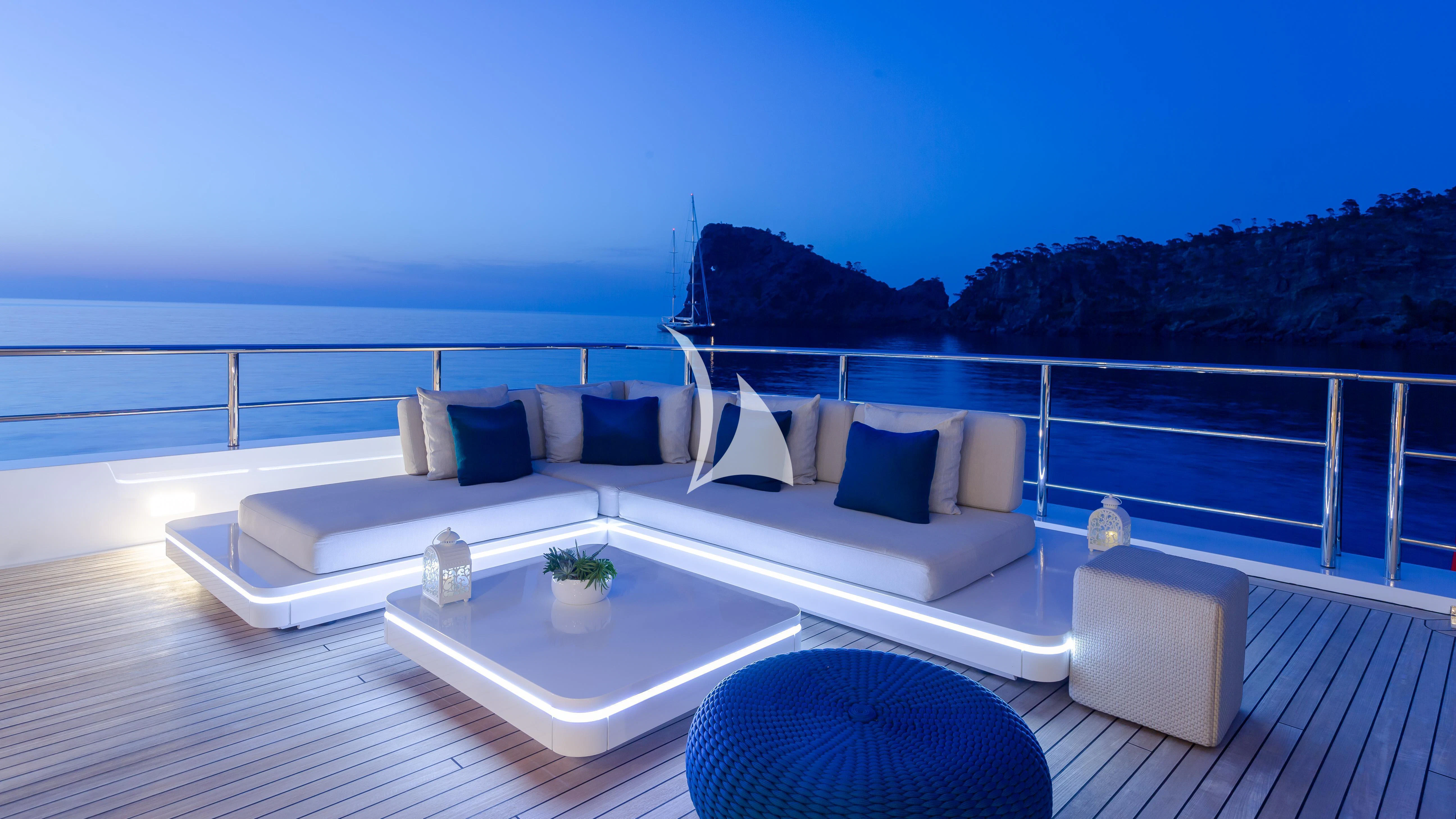 a white couch on a deck overlooking a large body of water aboard STELLA MARIS Yacht for Sale