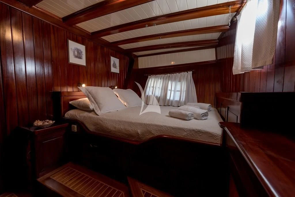 a room with a bed and a window aboard ERATO Yacht for Charter