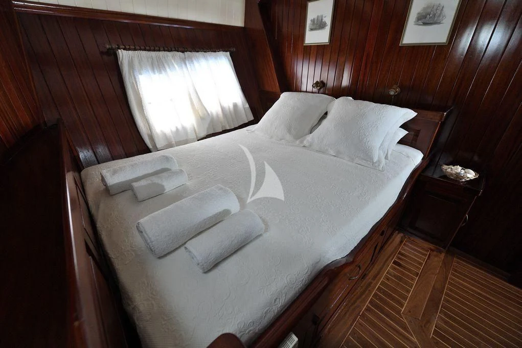 a bed with white sheets aboard ERATO Yacht for Charter