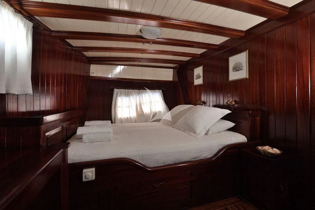 a bed with a white sheet aboard ERATO Yacht for Charter