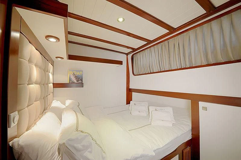 a room with a bed and a wood headboard aboard COBRA III Yacht for Sale