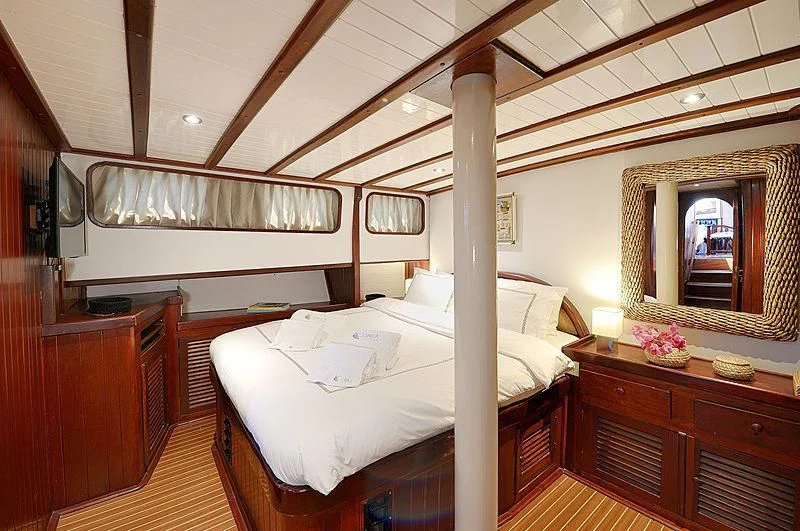 a room with a bed and a mirror aboard COBRA III Yacht for Sale
