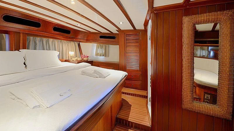 a room with a bed and a chair aboard COBRA III Yacht for Sale