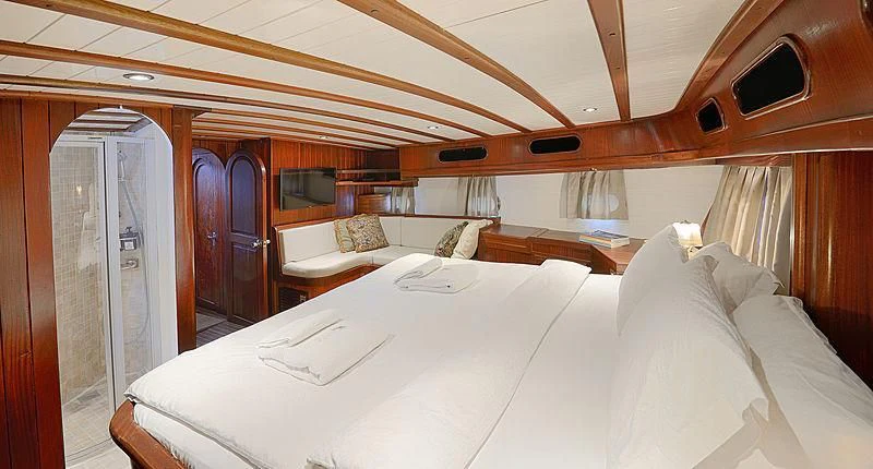 a room with a bed and a window aboard COBRA III Yacht for Sale