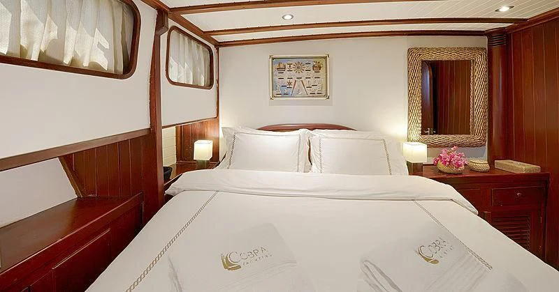 a bed with white sheets aboard COBRA III Yacht for Sale