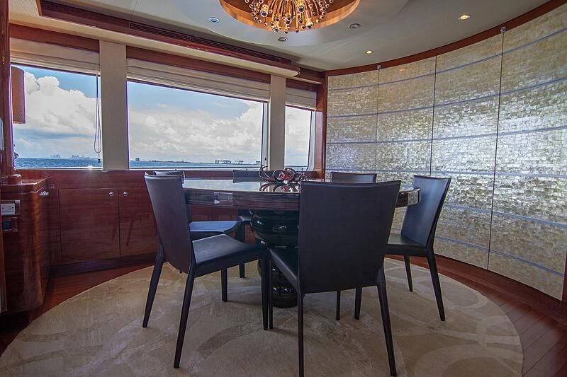 a dining table and chairs in a room with a window aboard SAMARITANA Yacht for Sale