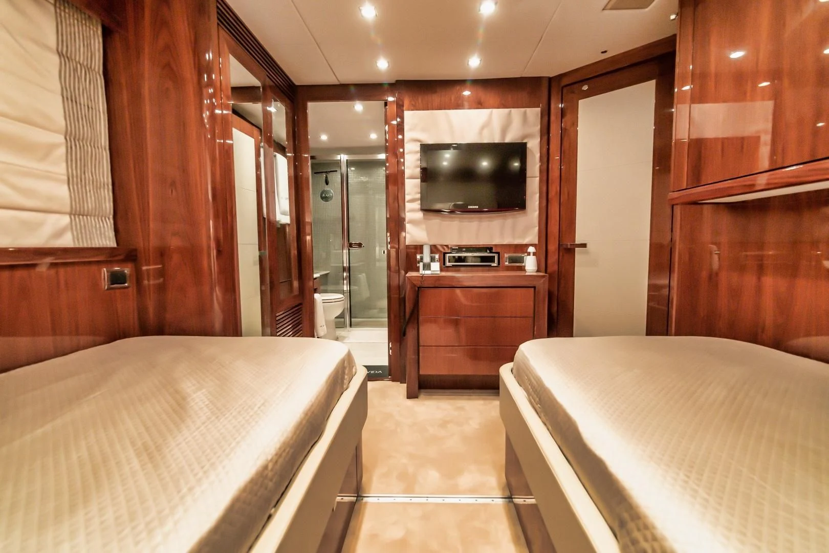 a bedroom with a bed and a television aboard VIVA LA VIDA Yacht for Sale