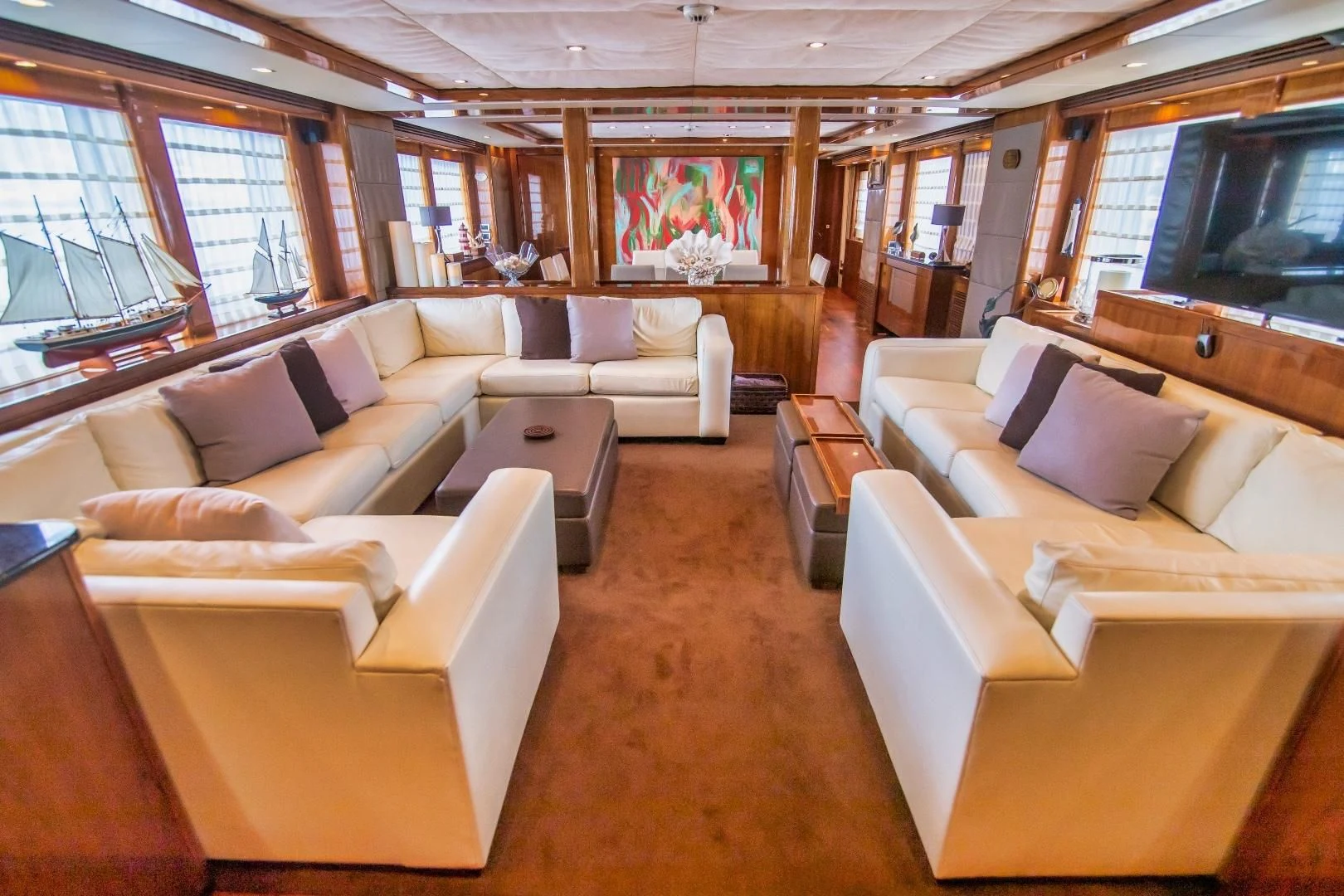 a large room with couches and a tv aboard VIVA LA VIDA Yacht for Sale