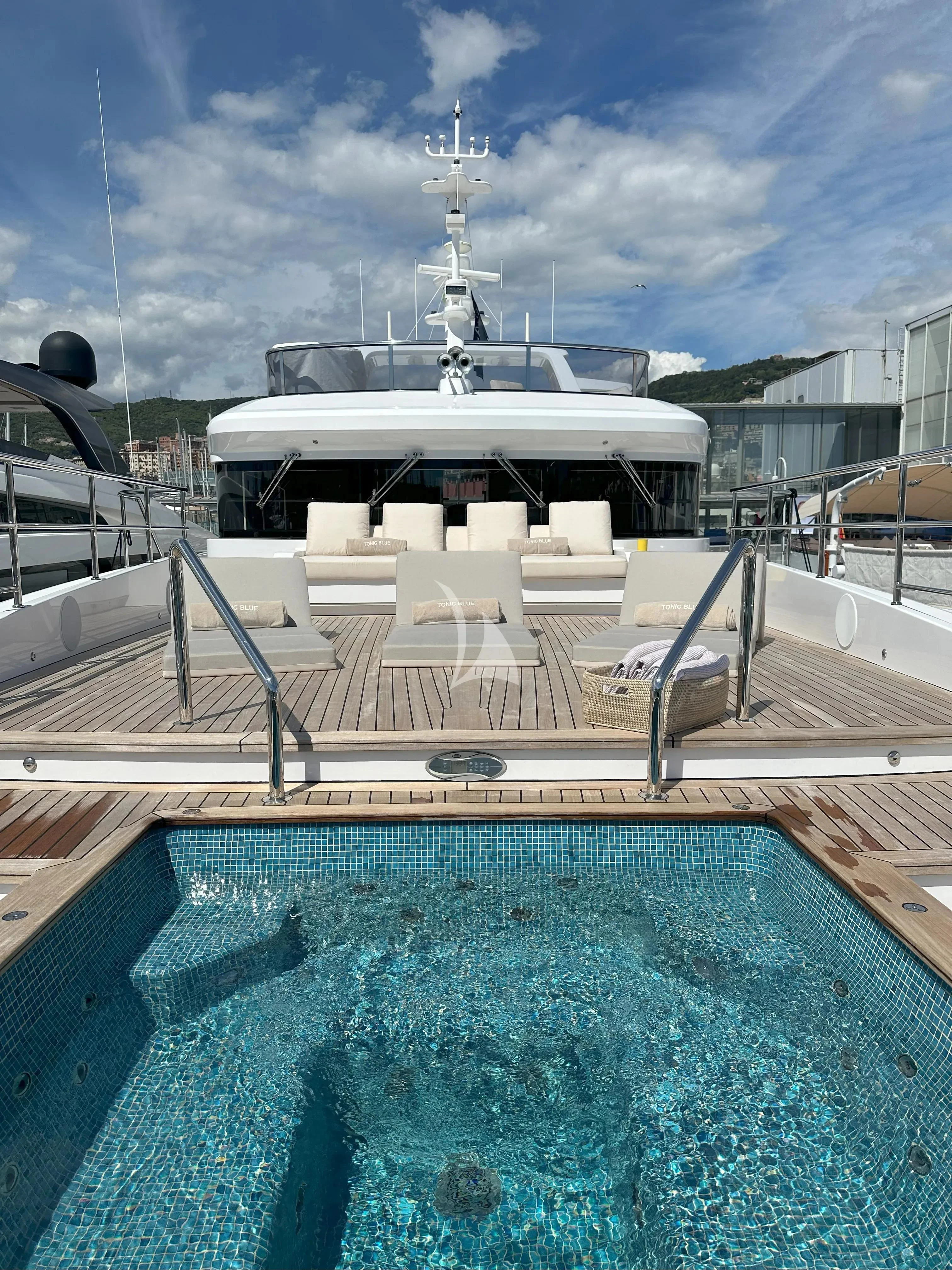 a swimming pool with a building in the background aboard TONIC BLUE Yacht for Sale
