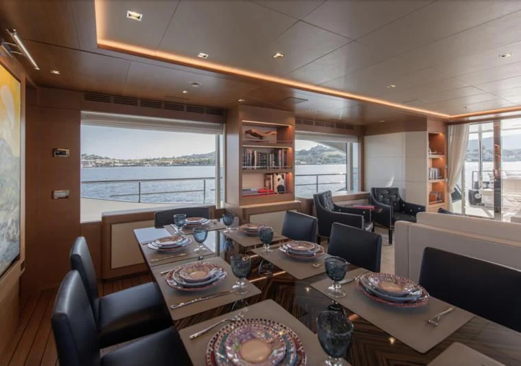 a dining room with a large window aboard TONIC BLUE Yacht for Sale