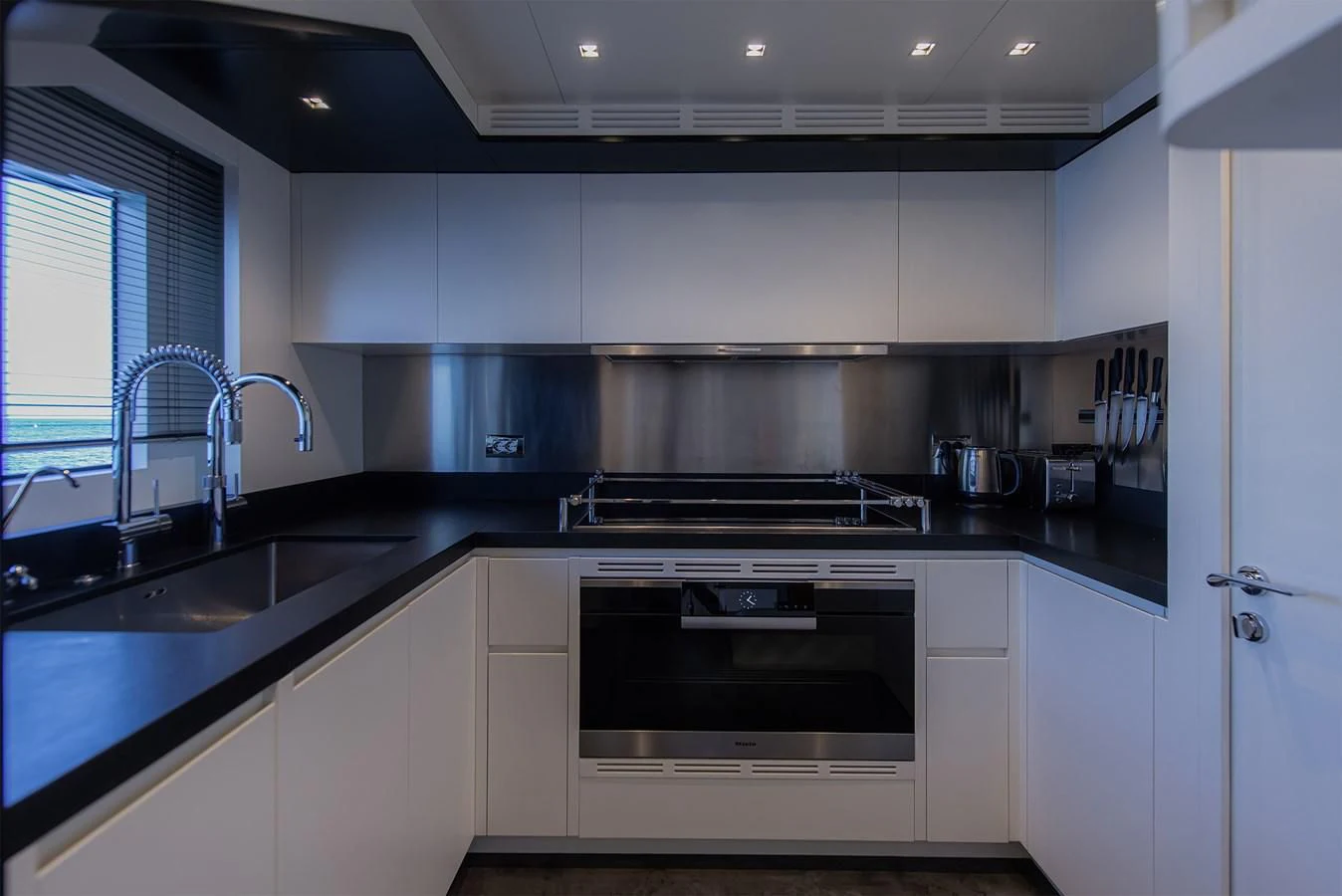 a kitchen with white cabinets aboard TONIC BLUE Yacht for Sale