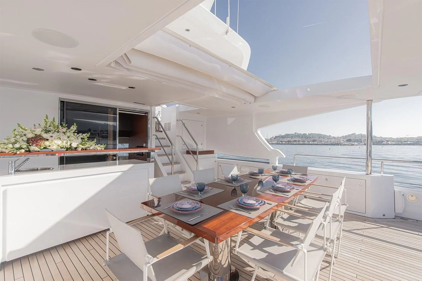 a large open area with a table and chairs and a large window aboard TONIC BLUE Yacht for Sale