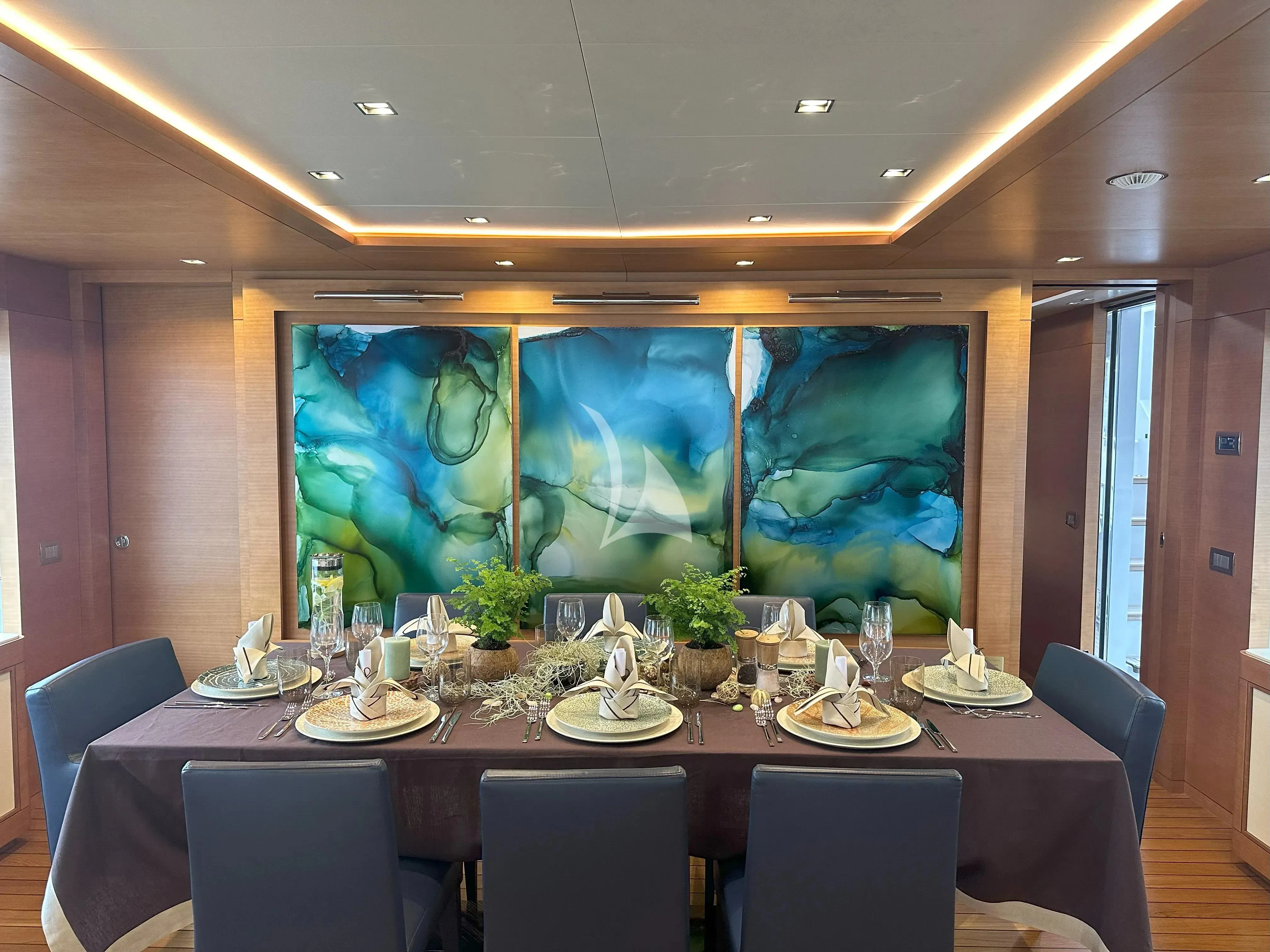 a large table with plates and glasses aboard TONIC BLUE Yacht for Sale
