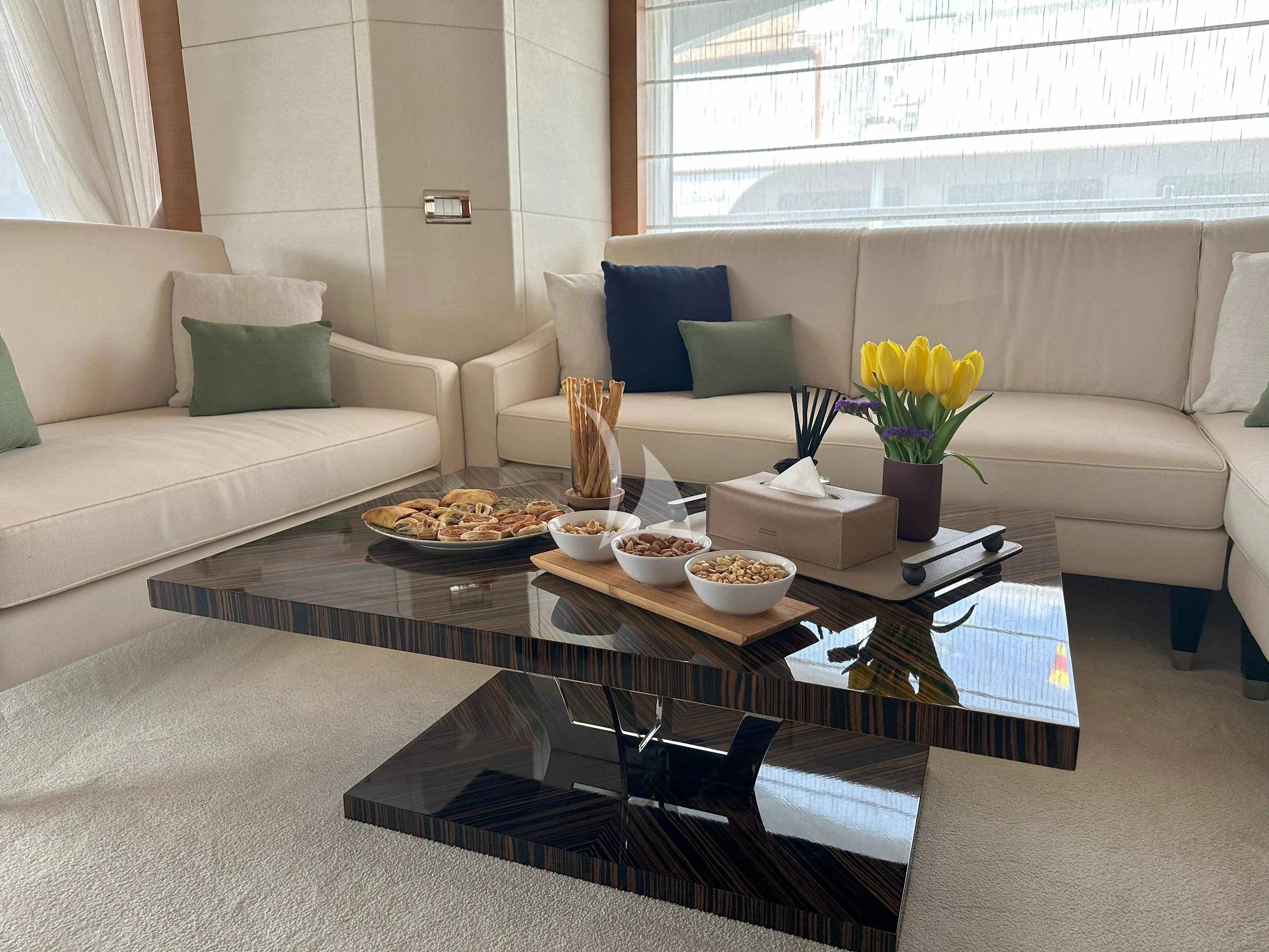 a living room with a table and couches aboard TONIC BLUE Yacht for Sale