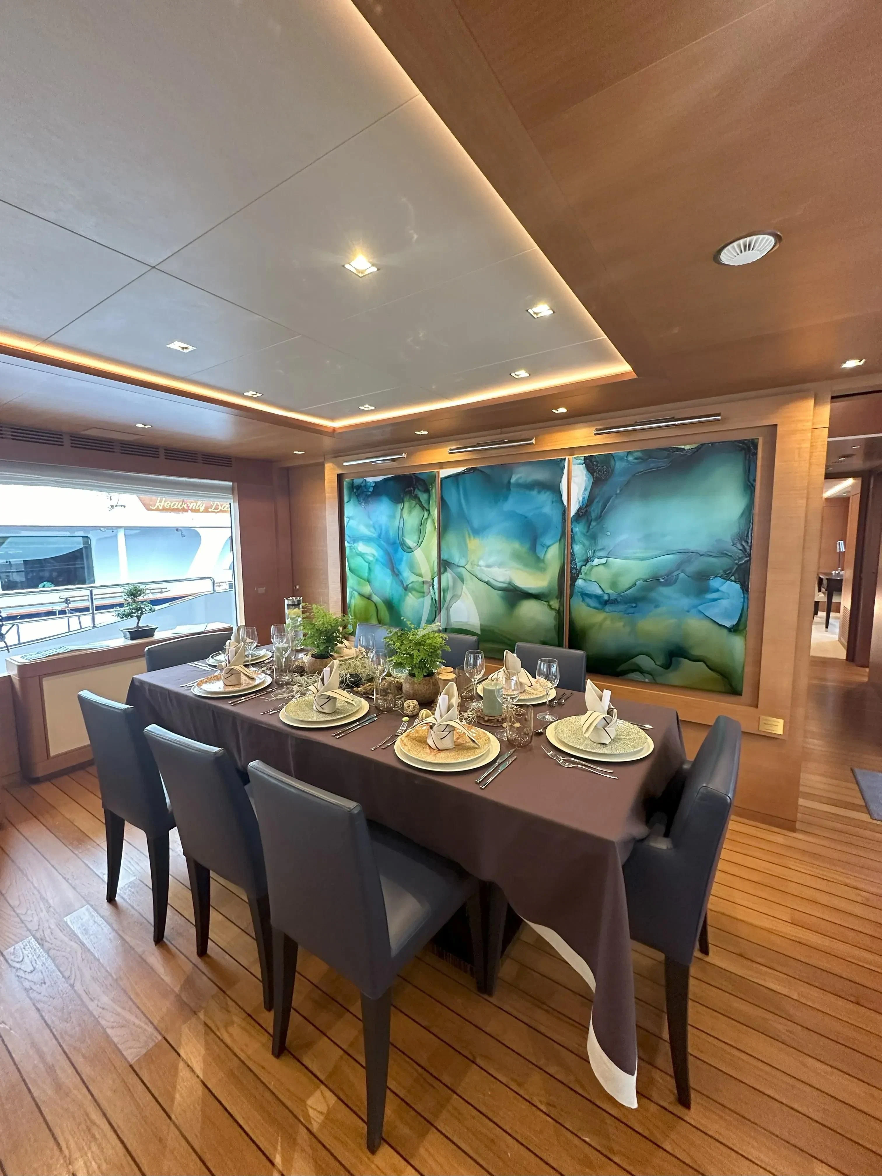 a dining table with a large screen aboard TONIC BLUE Yacht for Sale