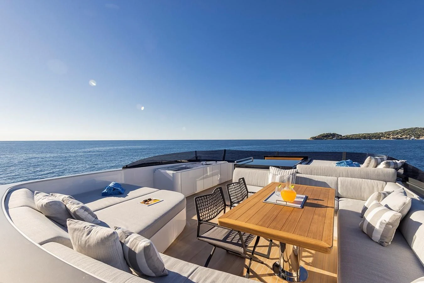 a room with a bed and a table and chairs on the beach aboard SOLEIL Yacht for Sale