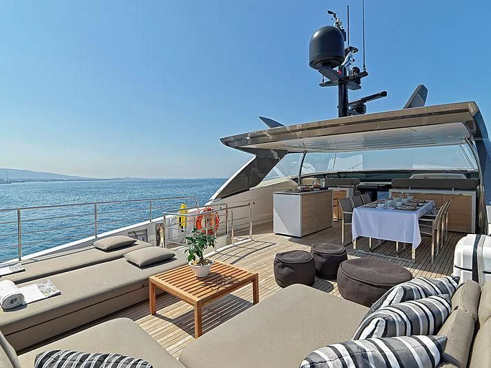 a deck with a table and chairs on it aboard CASA Yacht for Sale
