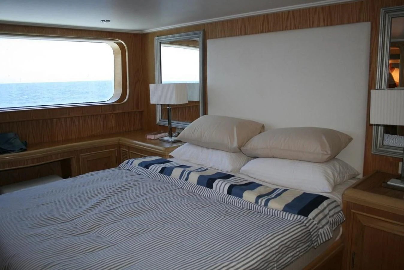 a bedroom with a bed and a window aboard SCUBA SCENE Yacht for Sale