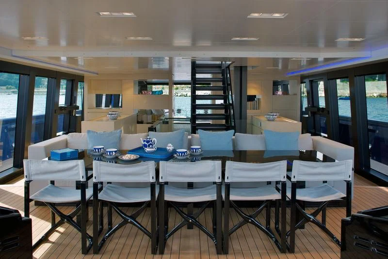 a dining room with white chairs and a staircase aboard BETTER PLACE Yacht for Sale
