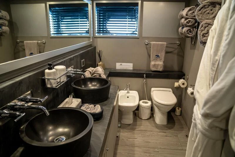 a bathroom with a sink toilet and a mirror aboard BABYLON Yacht for Sale