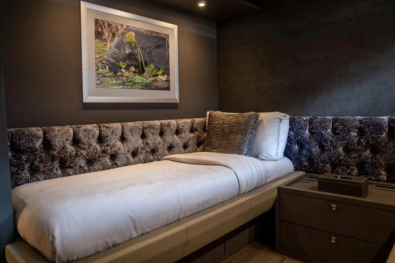 a bed with a painting on the wall aboard BABYLON Yacht for Sale