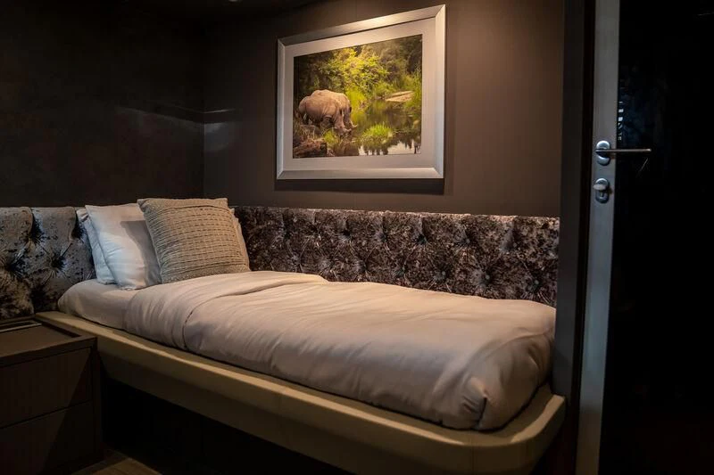 a bed with a painting on the wall aboard BABYLON Yacht for Sale