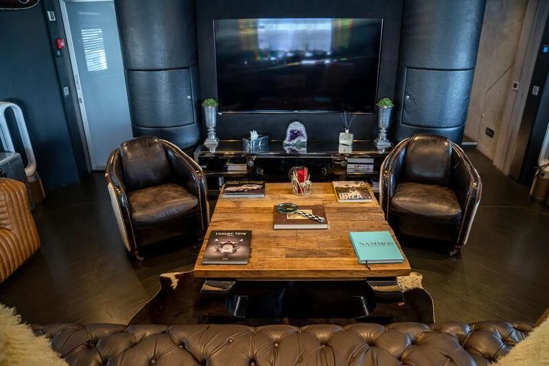 a living room with a leather chair and a table aboard BABYLON Yacht for Sale