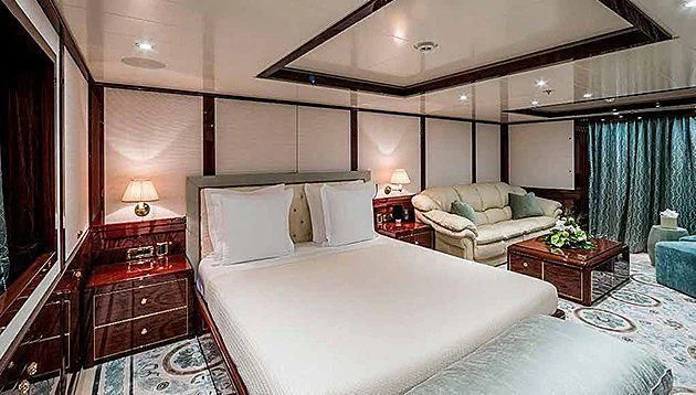 a room with a bed and a couch aboard LA FAMILIA Yacht for Sale