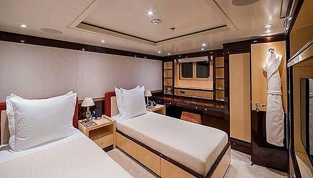 a room with a bed and a dresser aboard LA FAMILIA Yacht for Sale