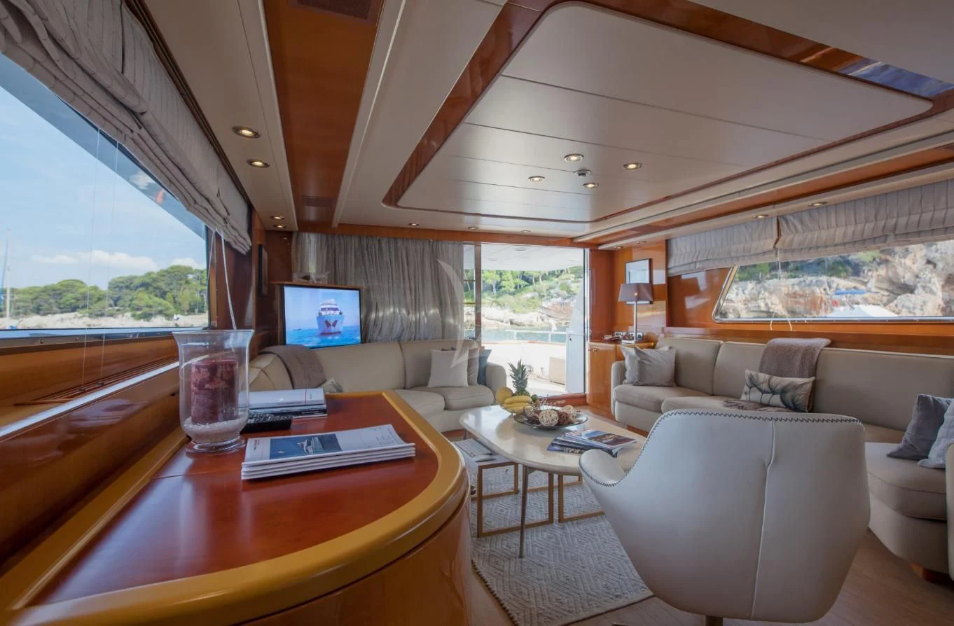 a living room with a table and a tv aboard SOLAL Yacht for Sale