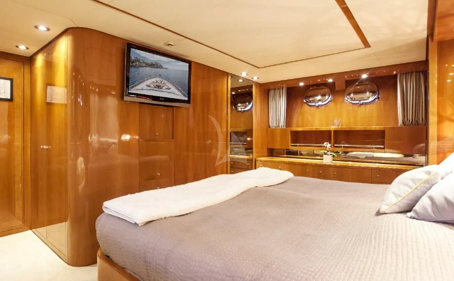a room with a bed and a wood wall aboard SOLAL Yacht for Sale