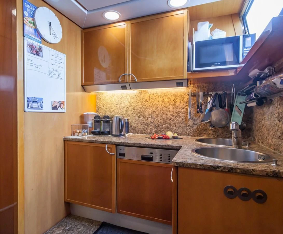 a kitchen with wooden cabinets aboard SOLAL Yacht for Sale
