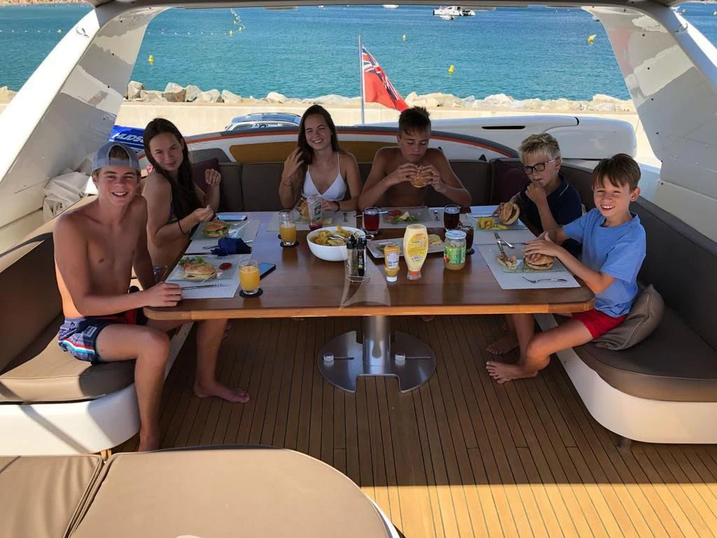a group of people sitting at a table with food on it aboard SOLAL Yacht for Sale
