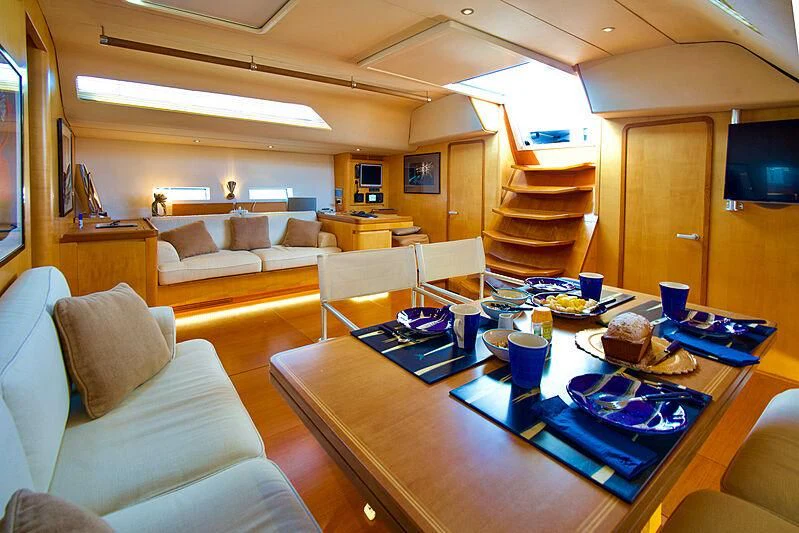 a living room with a table and couches aboard MAGIC BLUE Yacht for Sale