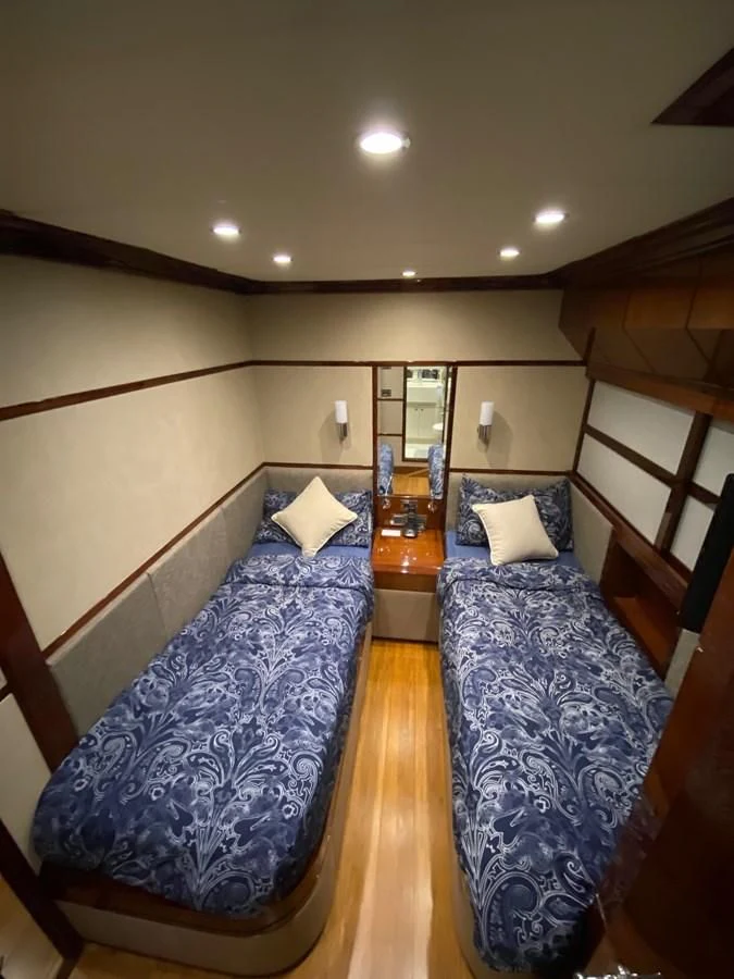 a bed with blue sheets aboard SERDAL Yacht for Sale