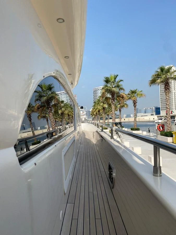 a white building with a railing and palm trees and a blue sky aboard SERDAL Yacht for Sale