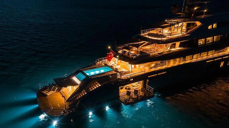 a large boat at night aboard TATIANA Yacht for Sale