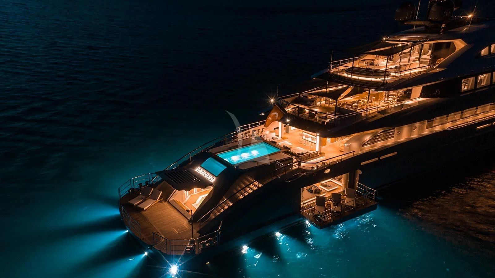 a large building with a pool at night aboard TATIANA Yacht for Sale