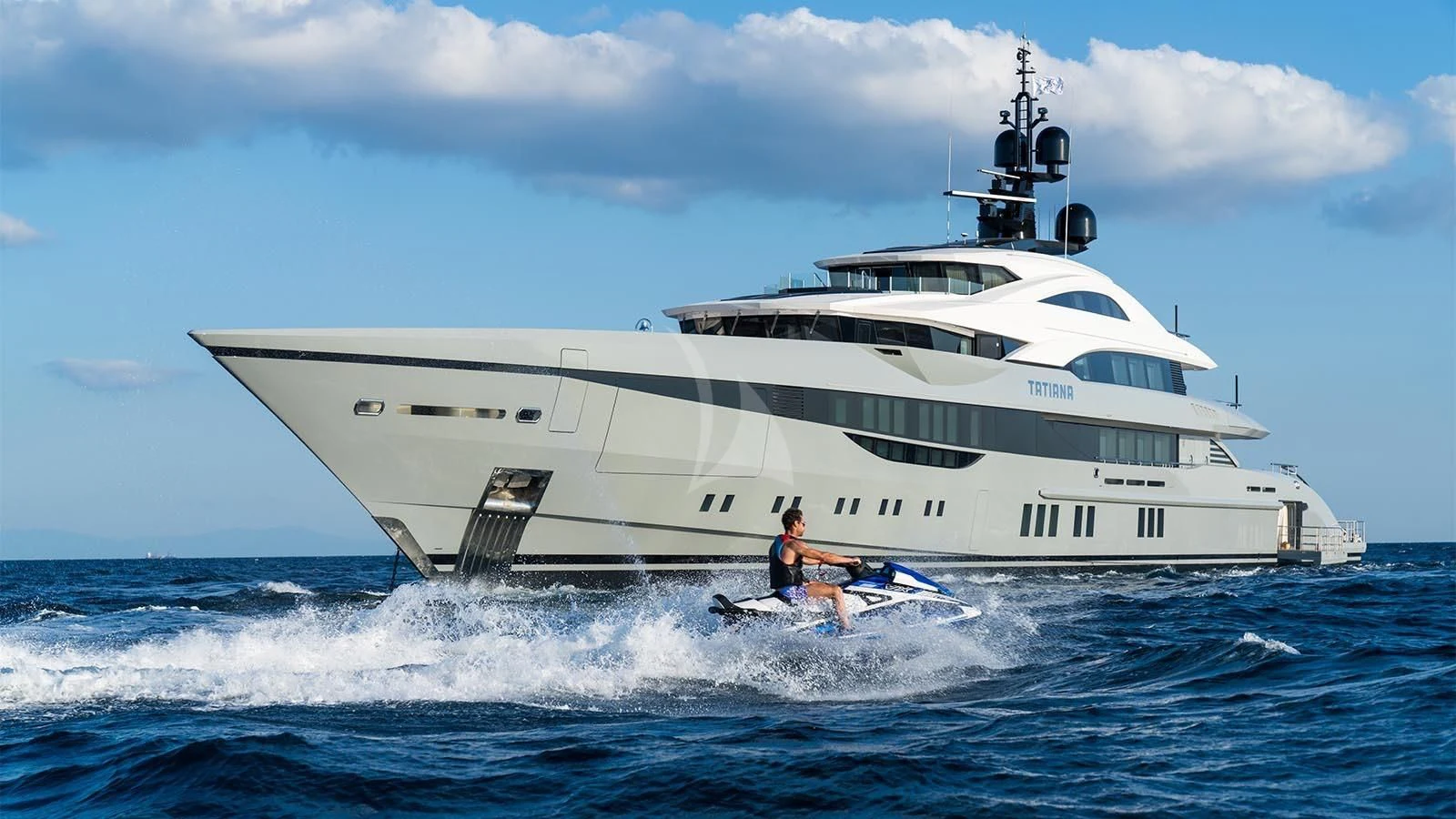 a person on a jet ski in the ocean next to a large white ship aboard TATIANA Yacht for Sale
