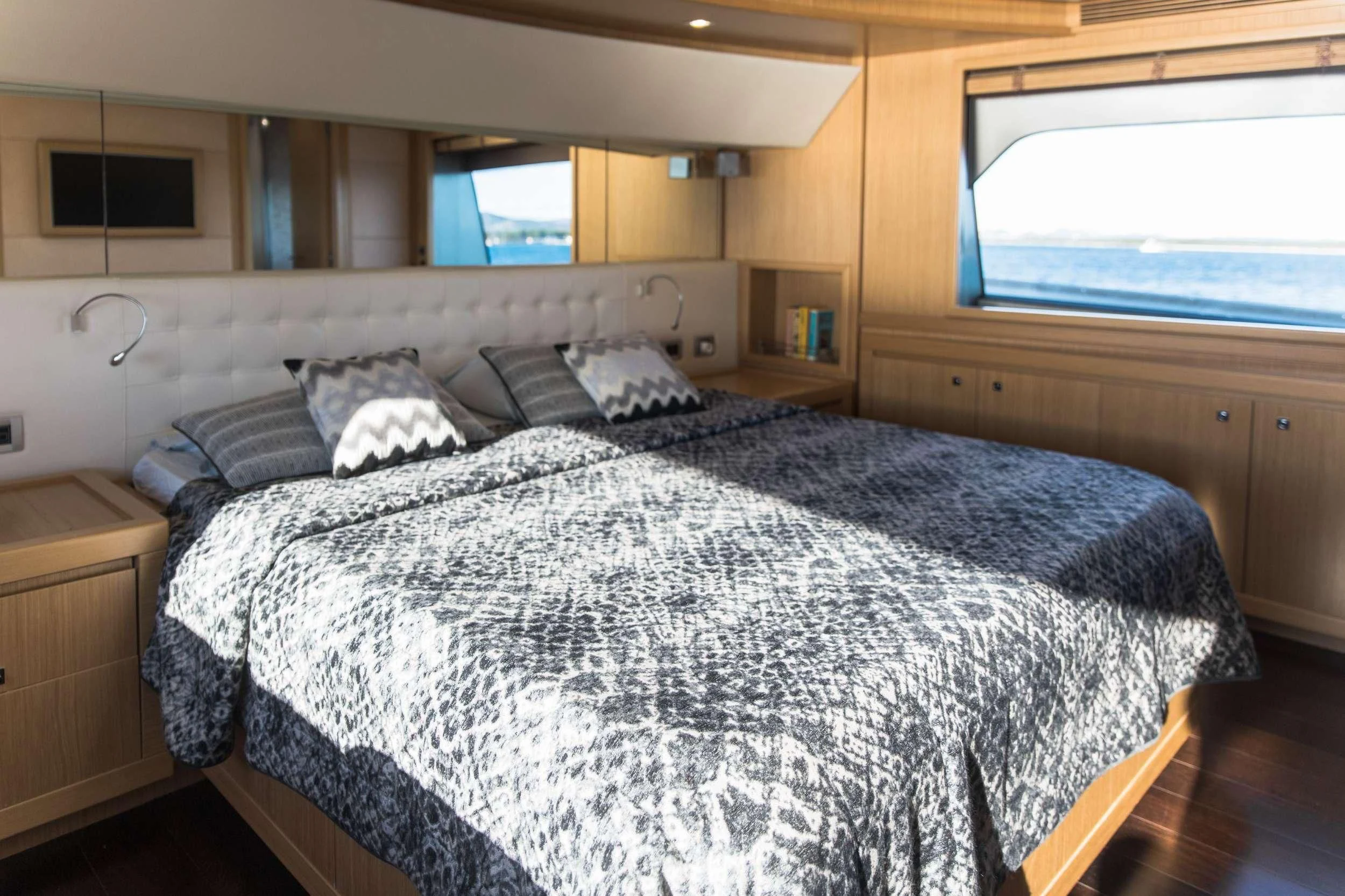 a bed with a blue comforter aboard FRIEND'S BOAT Yacht for Charter