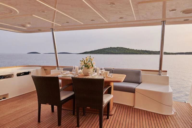a table and chairs on a deck aboard FRIEND'S BOAT Yacht for Charter