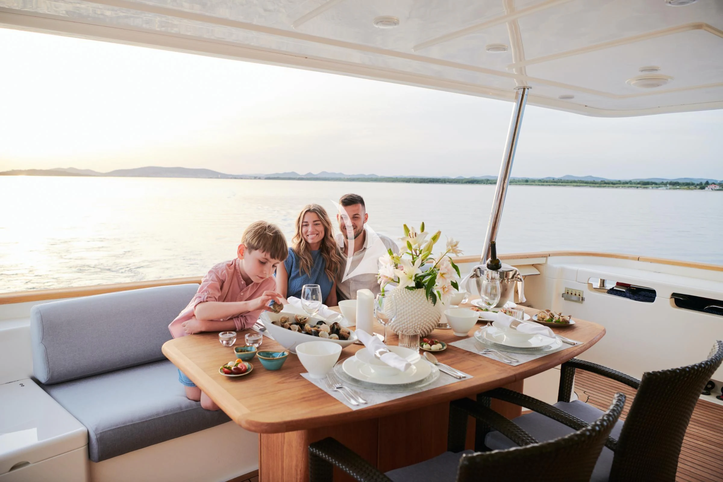 a family sitting at a table aboard FRIEND'S BOAT Yacht for Charter
