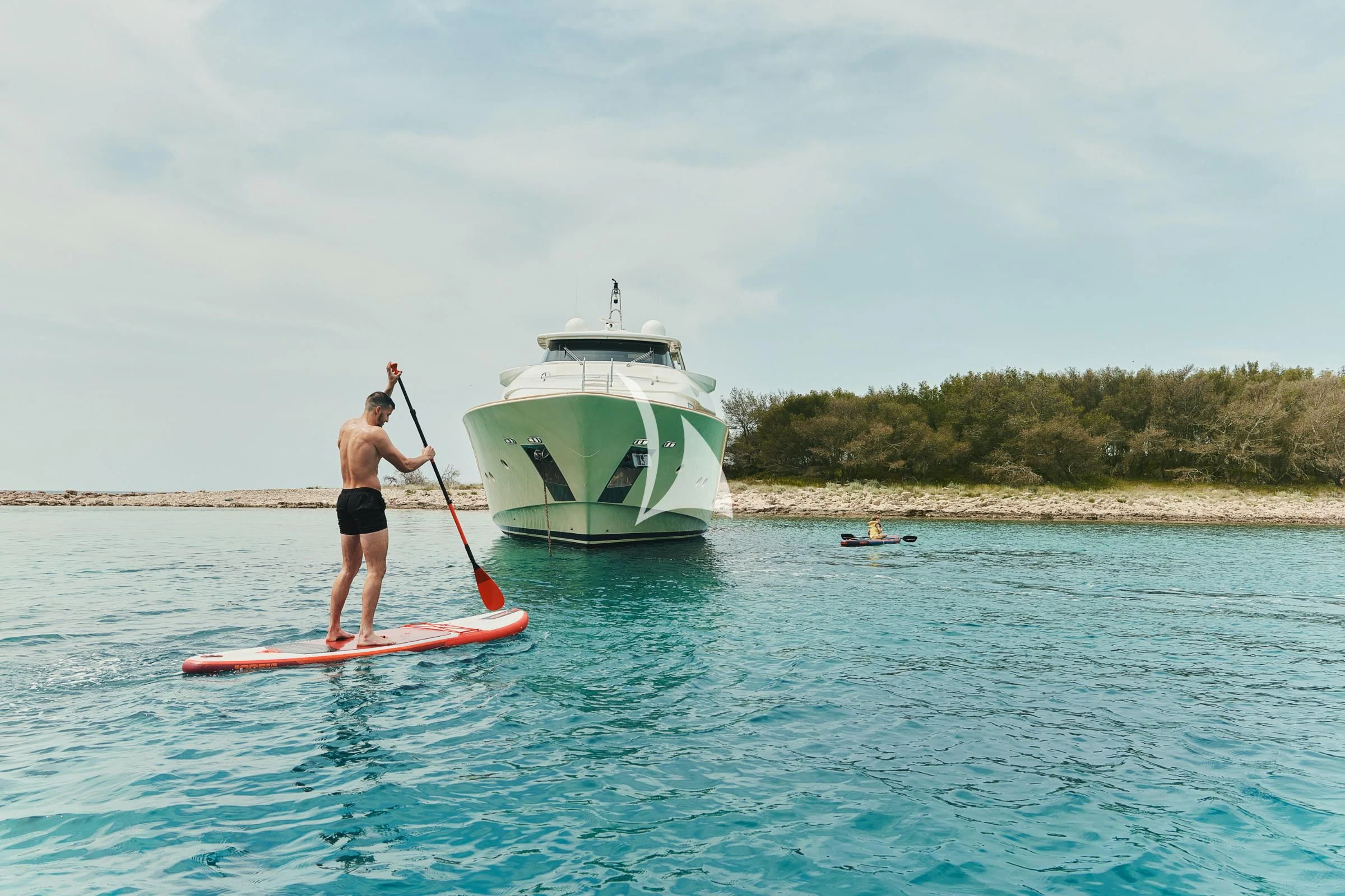 a man on a paddle board with a sailboat in the background aboard FRIEND'S BOAT Yacht for Charter