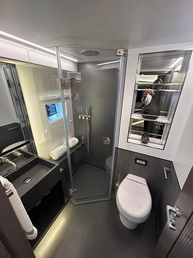 a bathroom with a glass shower aboard KNEAD IT Yacht for Sale