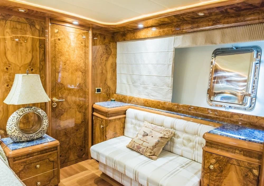 a bedroom with a bed and a mirror aboard HEMERA CUARTA Yacht for Sale