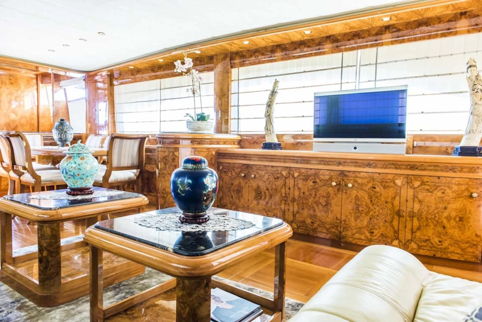 a living room with a tv and a table aboard HEMERA CUARTA Yacht for Sale
