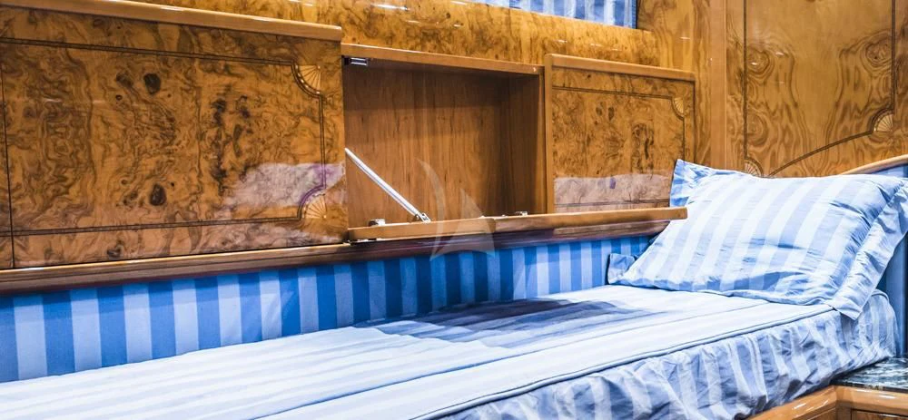 a bed with a blue sheet aboard HEMERA CUARTA Yacht for Sale