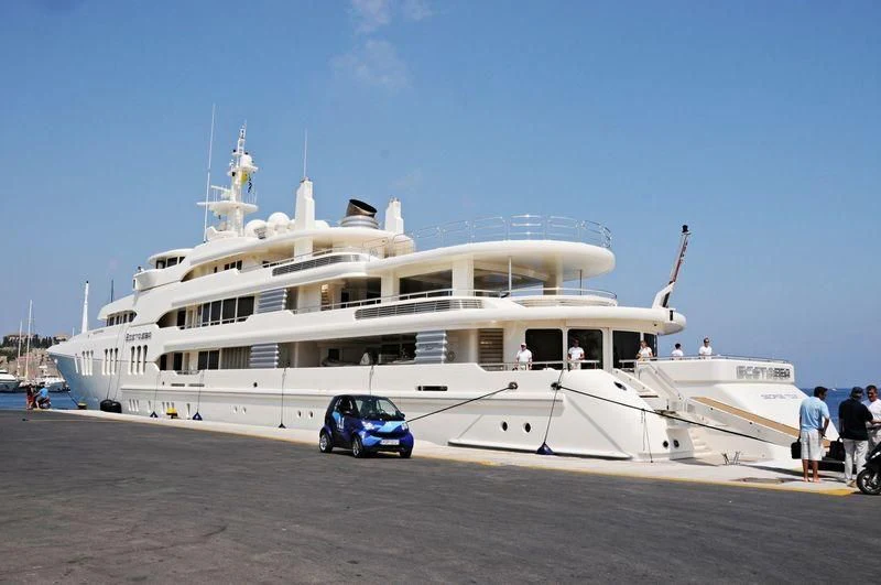 a large white boat with a car parked in front of it aboard ECSTASEA Yacht for Sale