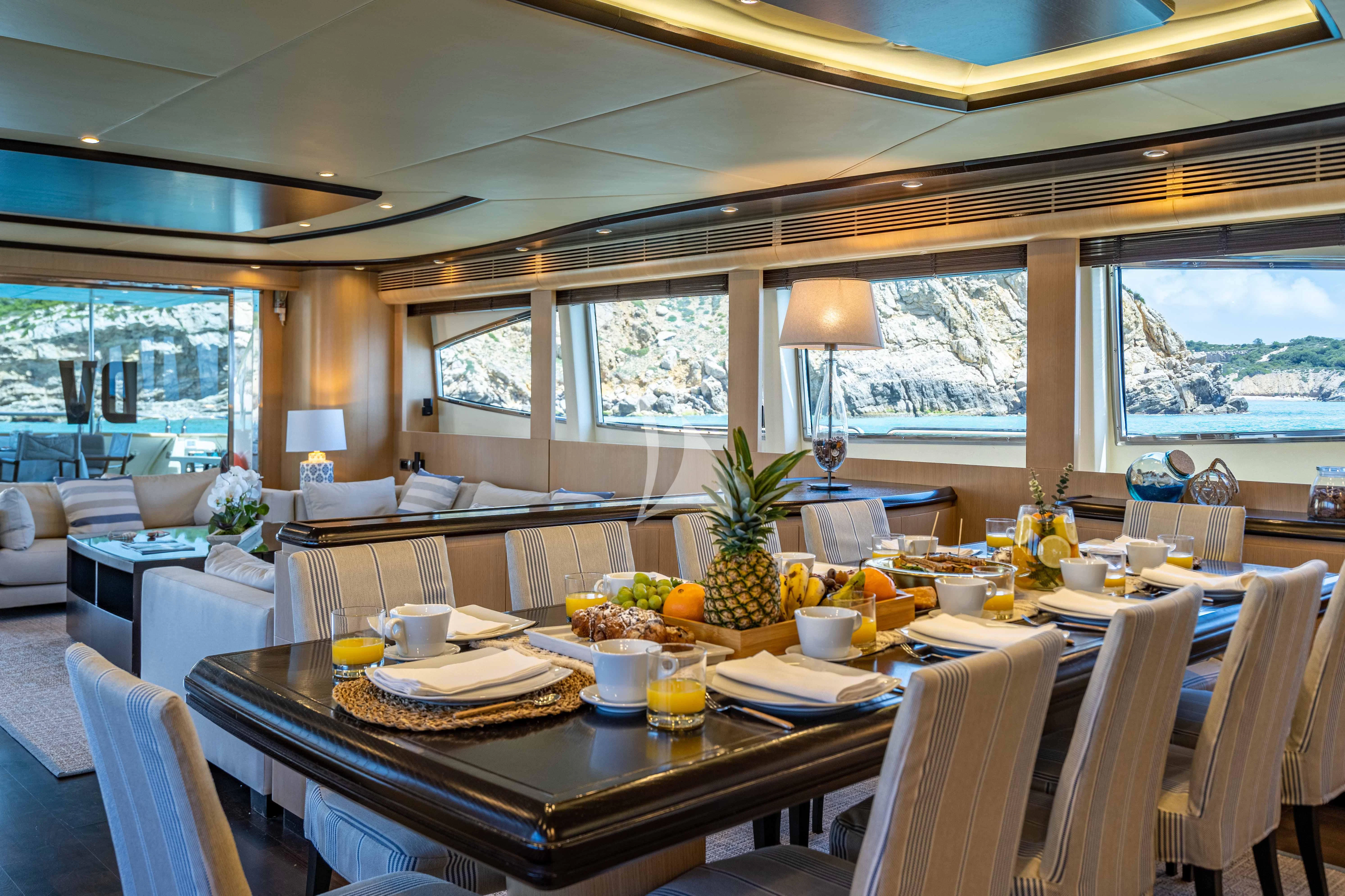 a dining table with a large window aboard DOLCE VITA IV Yacht for Sale